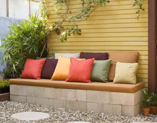 beton bir bankın üstüne konmuş rengarenk yastıklar