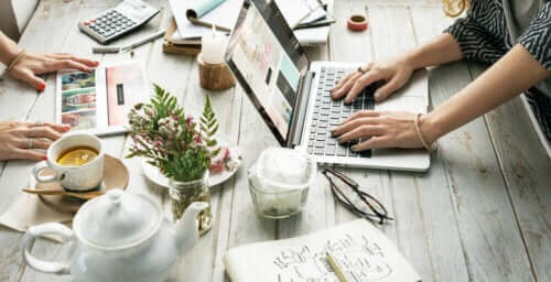 Masa üstünde kahveler, bitkiler ve bilgisayarlar