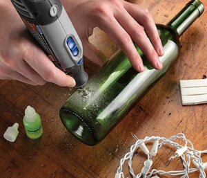 Bir el matkabı ile cam bir şişede delik açılıyor.